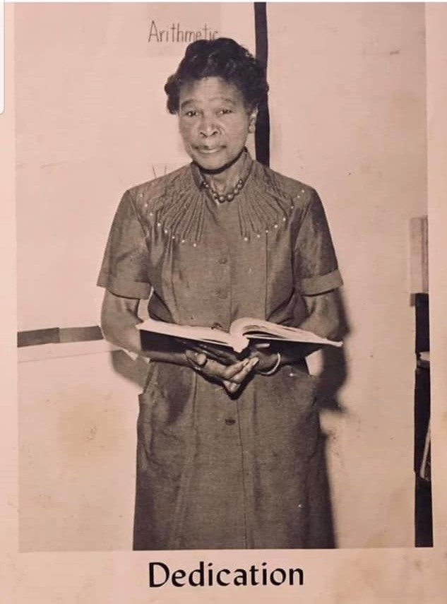 Mrs. Lougenia Roberts holding a book and smiling at the camera