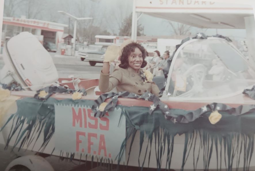 Lena Cooper waving from a car that says Miss F.F.A