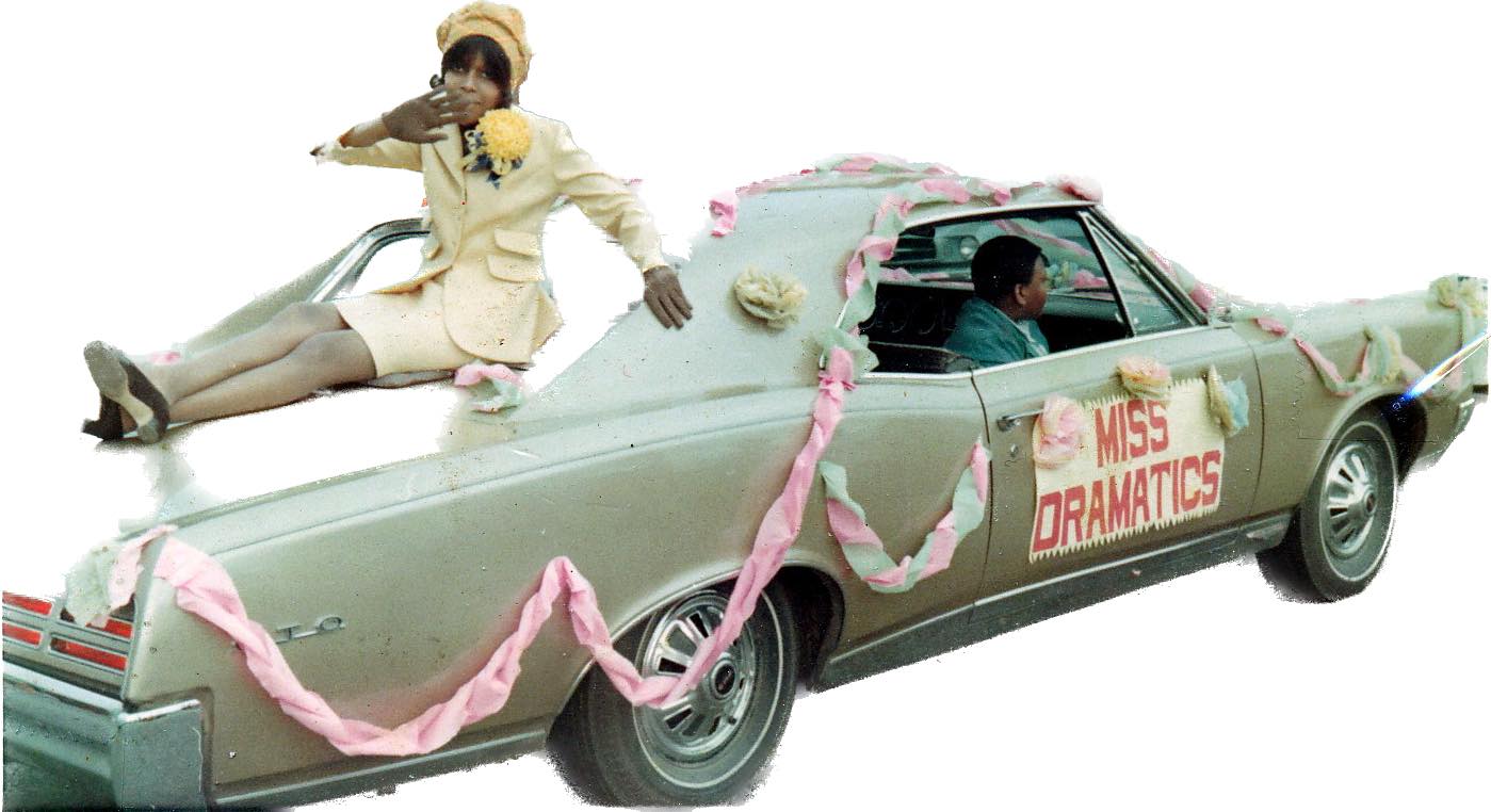 Brenda Joseph poses on top of a car that says Miss Dramatics