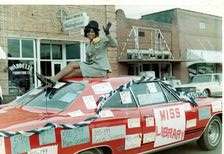 miss library waves while sitting on top of car